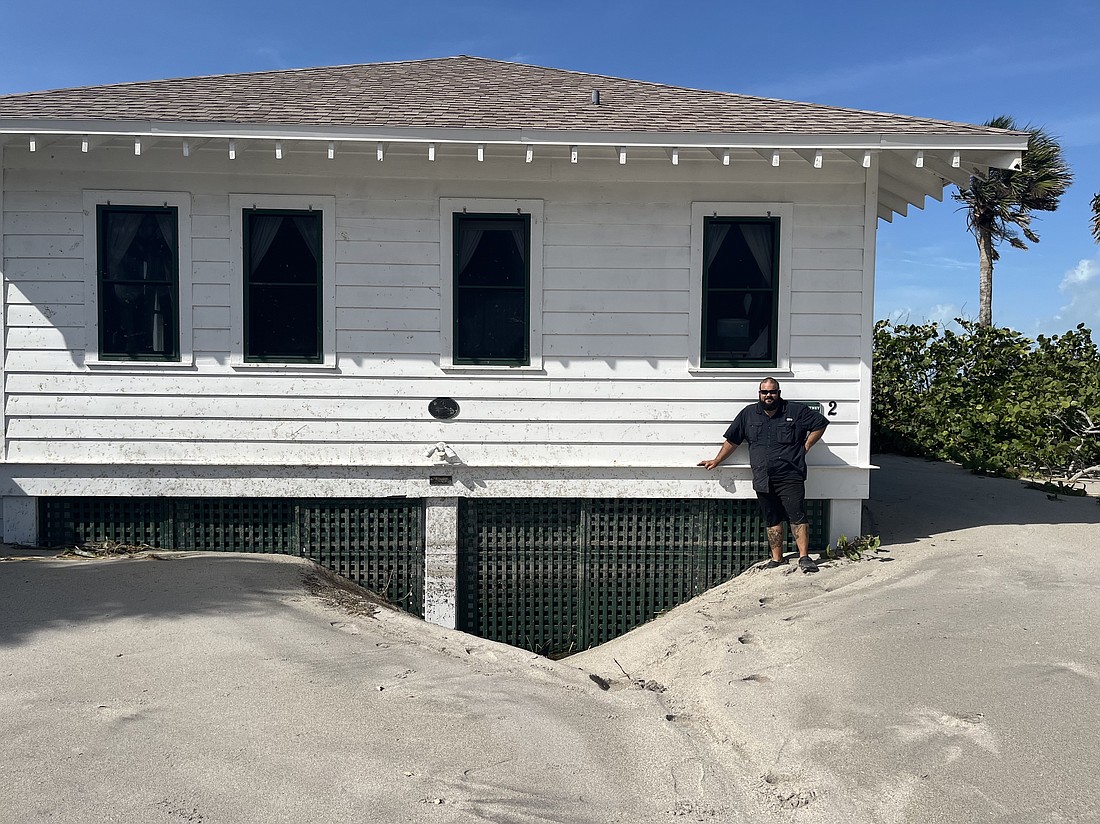 Sand dunes rise to nearly the top of the first floor at one of the Hermitage Retreat's historic buildings following Hurricane Helene.