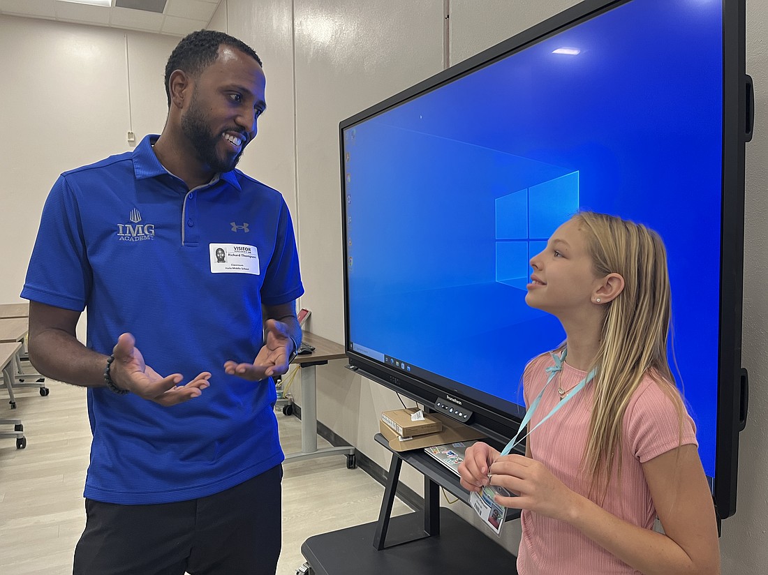 Olympian Richard Thompson talks to sixth grader Lauren Otterness after he talked to Otterness and her fellow scholars about goal setting.