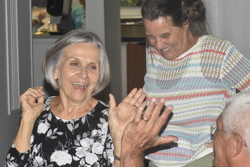Elaine Greenwood and Cathy Bolinger slap hands with Brian Bolinger as they finish doing the Chicken Dance.