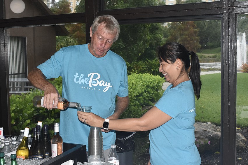 Paul Gresk and Marcy Nuncio work together to serve a drink.