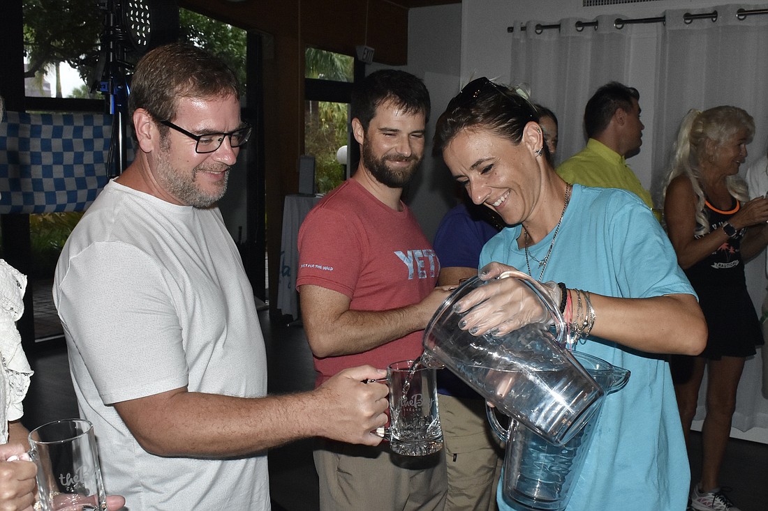 Bowen Griffitt and Brandon Scolaro prepare to start the stein hoisting competition as Vanya Krayhova fills their glasses with water.