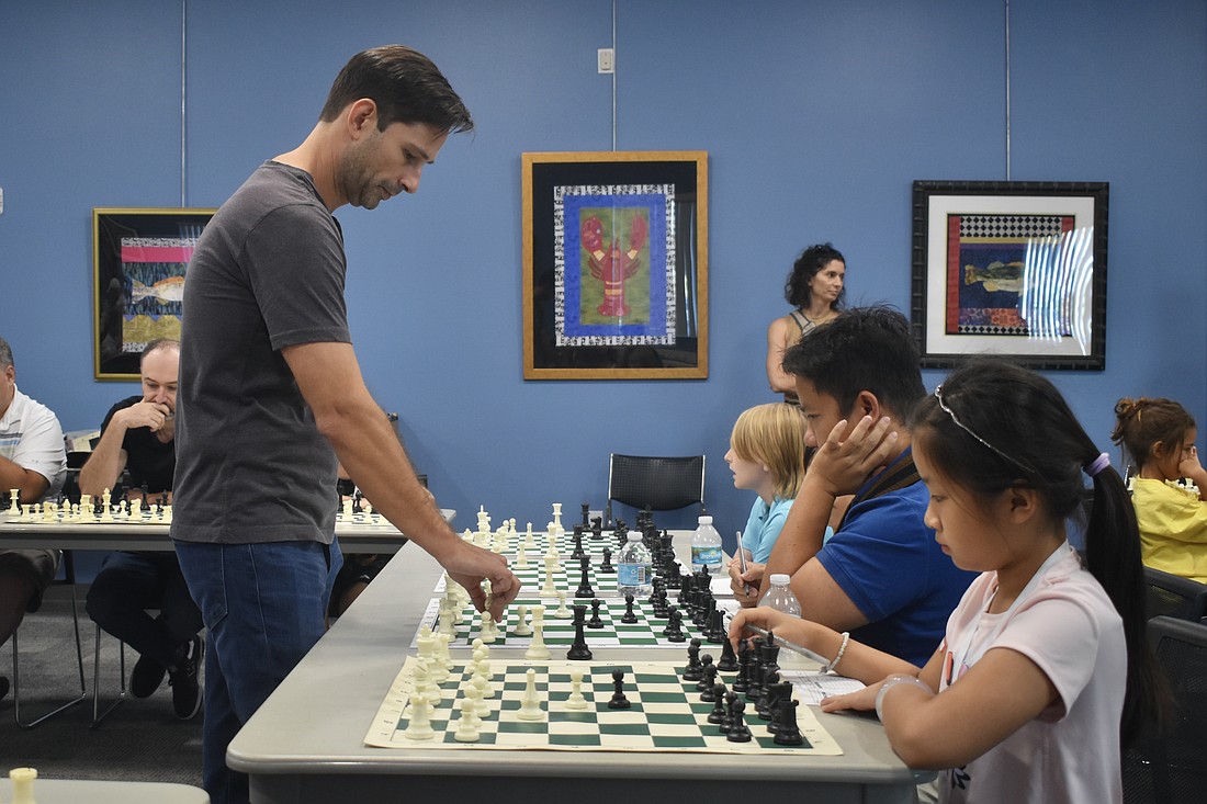 Pascal Charbonneau walks from one chess board to another as he performs the demonstration of 15 simultaneous games.