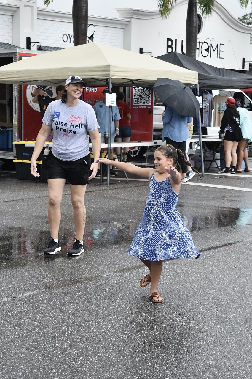 Patty Wacha of the Sarasota Firefighters Benevolent Fund and Madison Brown, 5, dance to the live music.