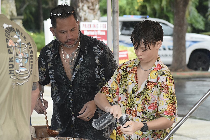 Joey Reyes helps Hunter Bertrand, 12, prepare chili at the Sarasota County stations 6 and 9 booth.