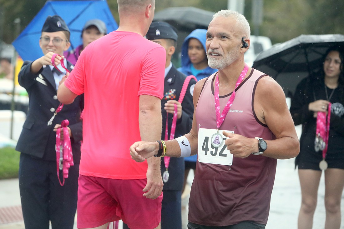 2024 Pink on Parade 5K winner Paolo Pais congratulates other runners as they finish the race. File photo by Brent Woronoff