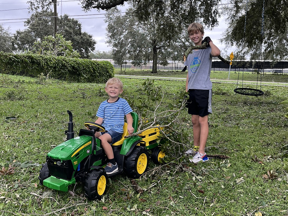 Dawson Peek, 5, and Ethan Peek, 11, worked diligently to get their front yard cleaned up following the hurricane