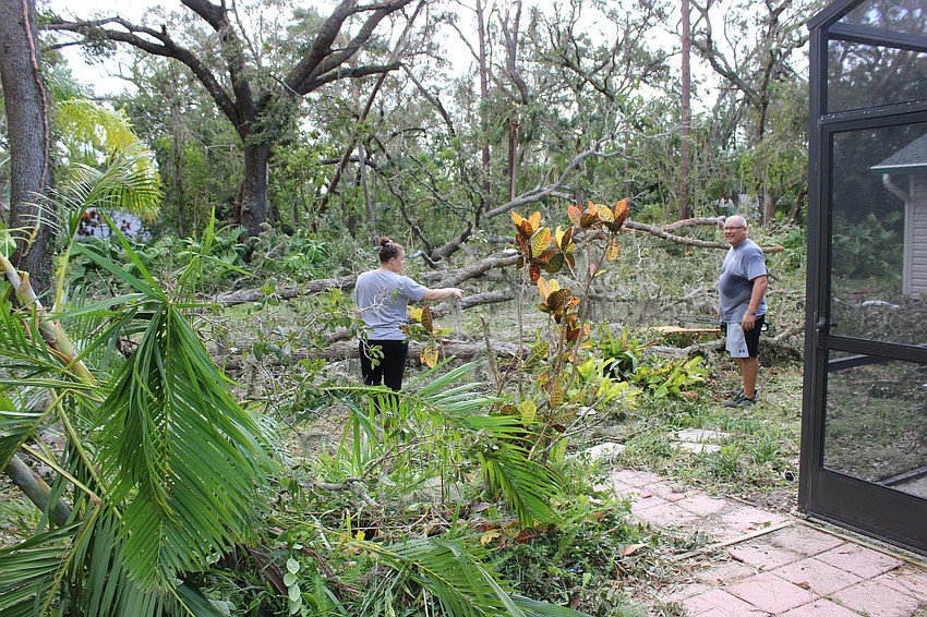 Sonny Fumagalli and her dad, Matthew Baialardo clean fallen trees from the backyard of her Braden Woods home on Thursday following Hurricane Milton.