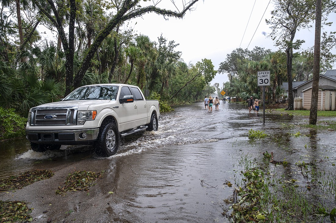 Ormond Beach residents traverse water on a flooded Shockney Dr. following Hurricane Milton. Photo by Michele Meyers