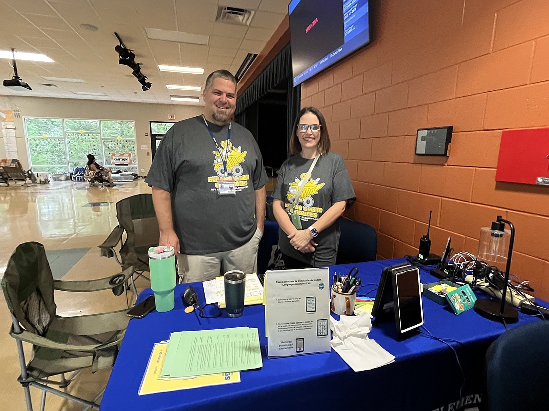 Daniel Bradshaw, the principal of Parrish Community High School, and Carol Ricks, the principal of Myakka City Elementary School, man the registration desk at Myakka City Elementary as it serves as a shelter during Hurricane Milton.