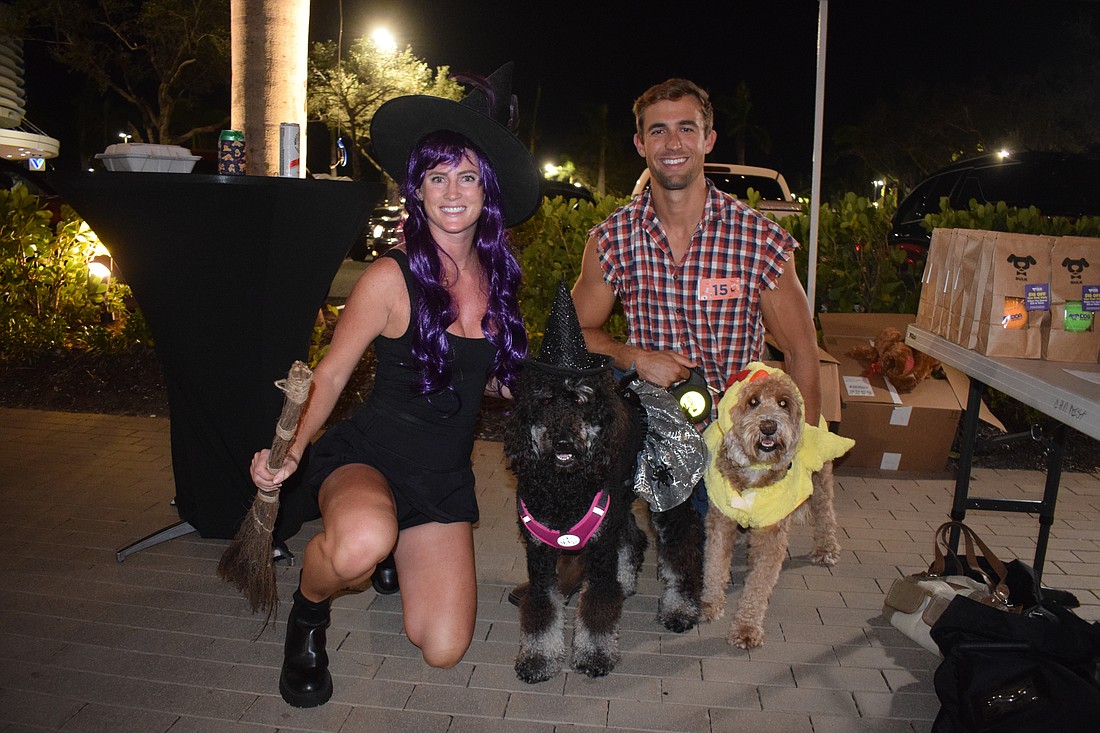 Bradenton's Eryn Skage dresses as a witch to match their dog Rye, while Scott Skage dresses as a farmer to go with their dog Whiskey, who is dressed as a chicken. Whiskey loves chasing chickens while the witch fits Rye's personality, Scott Skage says.