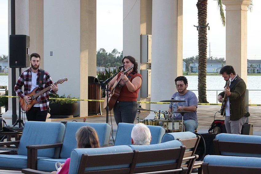 Kevin Mendel, Taylor Opie, Damon Owens and Andrew Glasgow entertain the crowd from in front of the Waterside Place pavilion, which was damaged by Hurricane Milton.