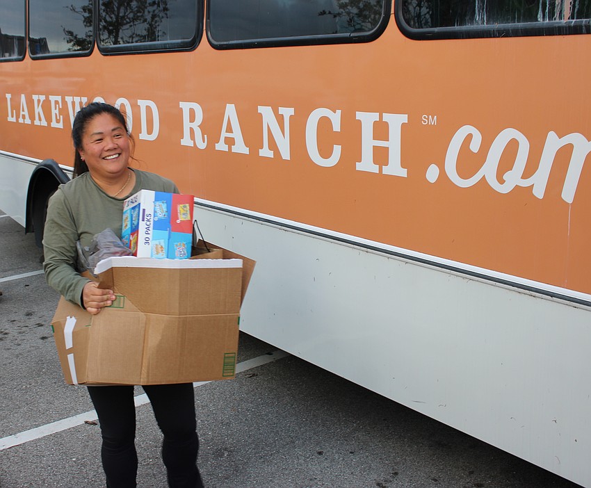 Morgan Bettes Angell carries donations to help those affected by Hurricane Milton to the Lakewood Ranch bus during Ranch Nite Wednesdays at Waterside Place.