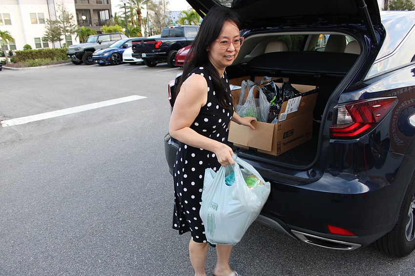 Sarasota's Susan Hong unloads donations at Ranch Nite Wednesdays during the Lakewood Ranch food and supplies drive.