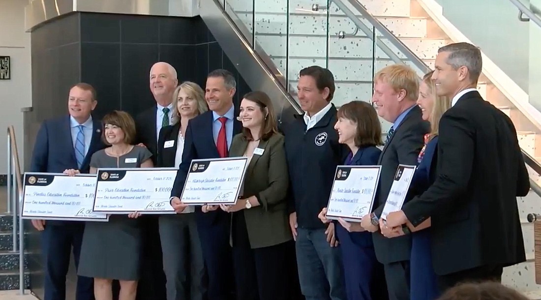 Gov. Ron DeSantis, speaking Thursday at Booker High School in Sarasota,  presented $100,000 checks to education foundations in Sarasota and Manatee counties.