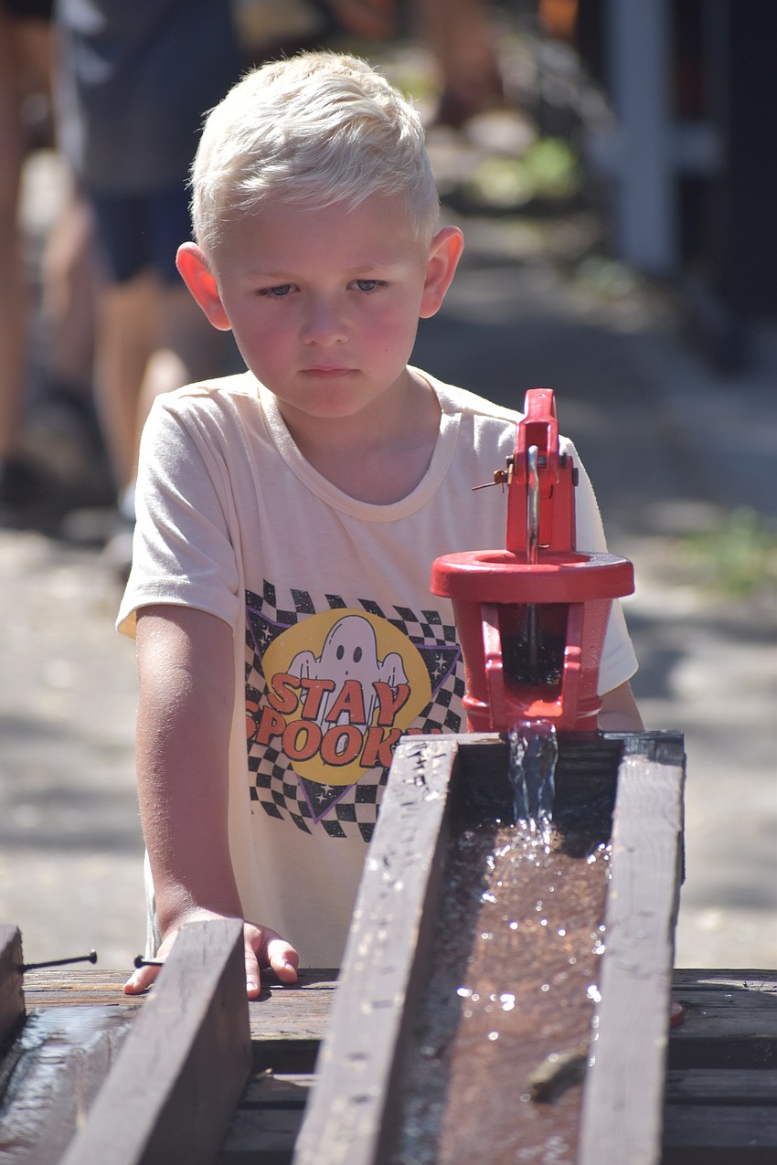 Logan Stockwell experiments with pouring water into a trough.