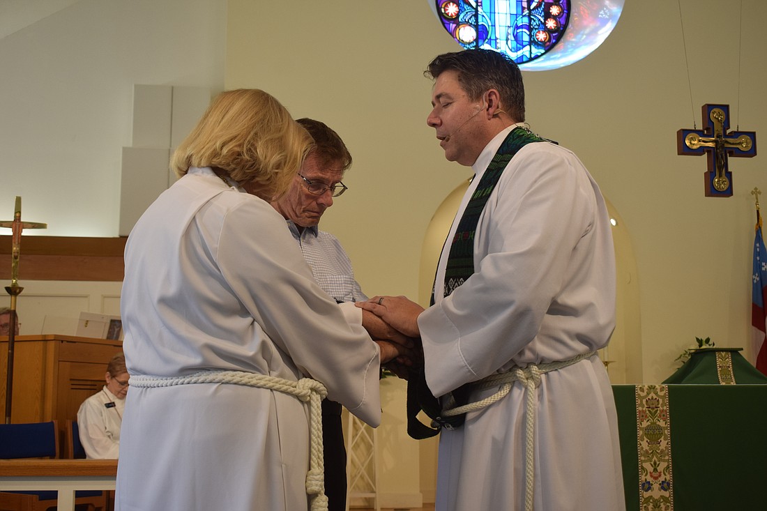 The Rev. David Marshall praying over BJ and David Bishop at All Angels By the Sea Episcopal Church.