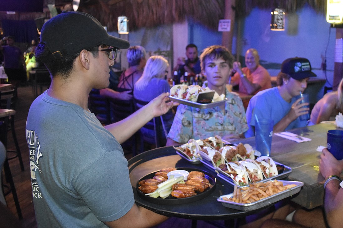 Christian Galicia serves Zac and Trey Yovanovich at Siesta Key Oyster Bar on Oct. 22.