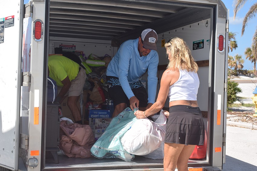 Tony Falagario and Sharon Austin unpacking the trailer of supplies collected by students from Milton High School in Georgia.
