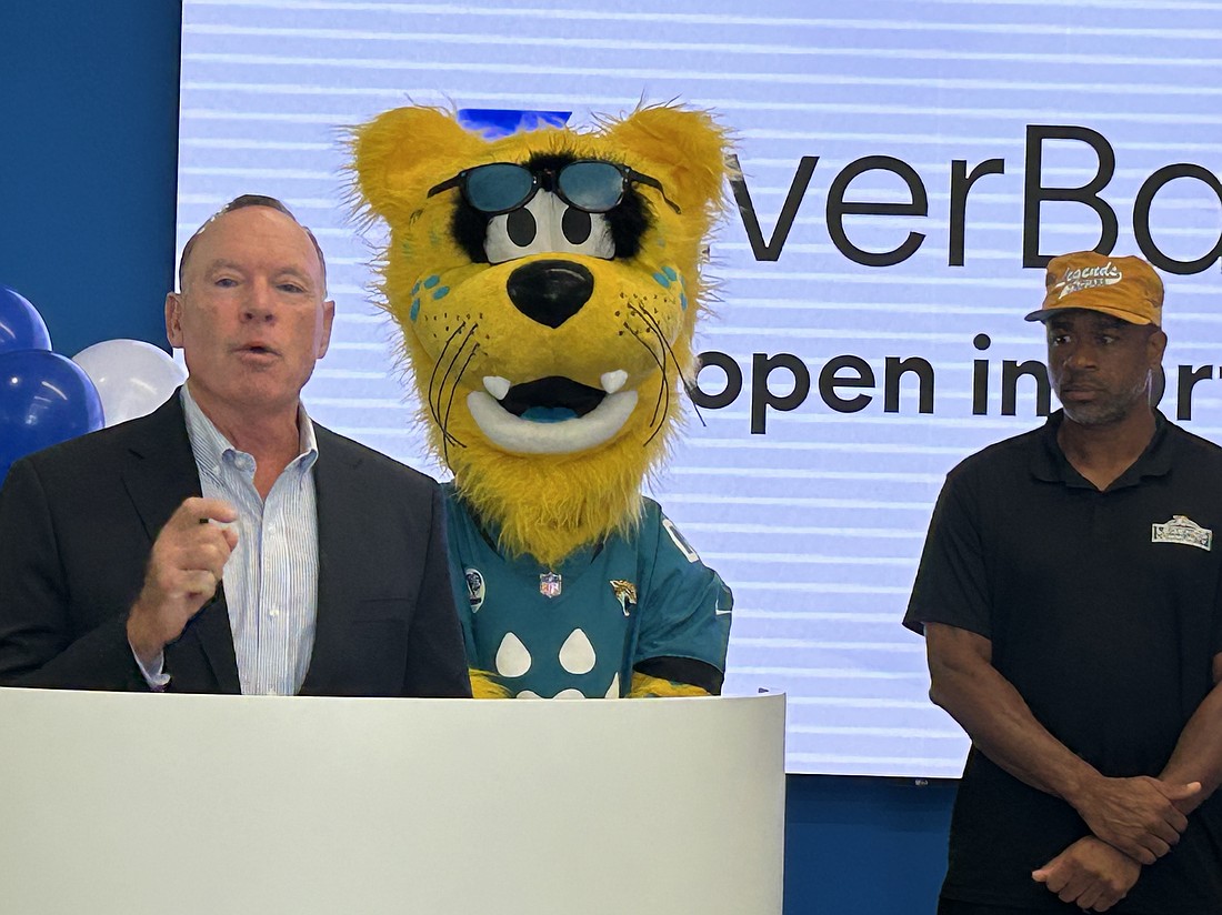 Curt Kunkle, left, Florida banking president at EverBank, and Aaron Beasley, a former cornerback for the Jacksonville Jaguars, flank Jaguars mascot Jaxson de Ville during a presentation at the ribbon-cutting Oct. 22 at Everbank Ortega Financial Center.