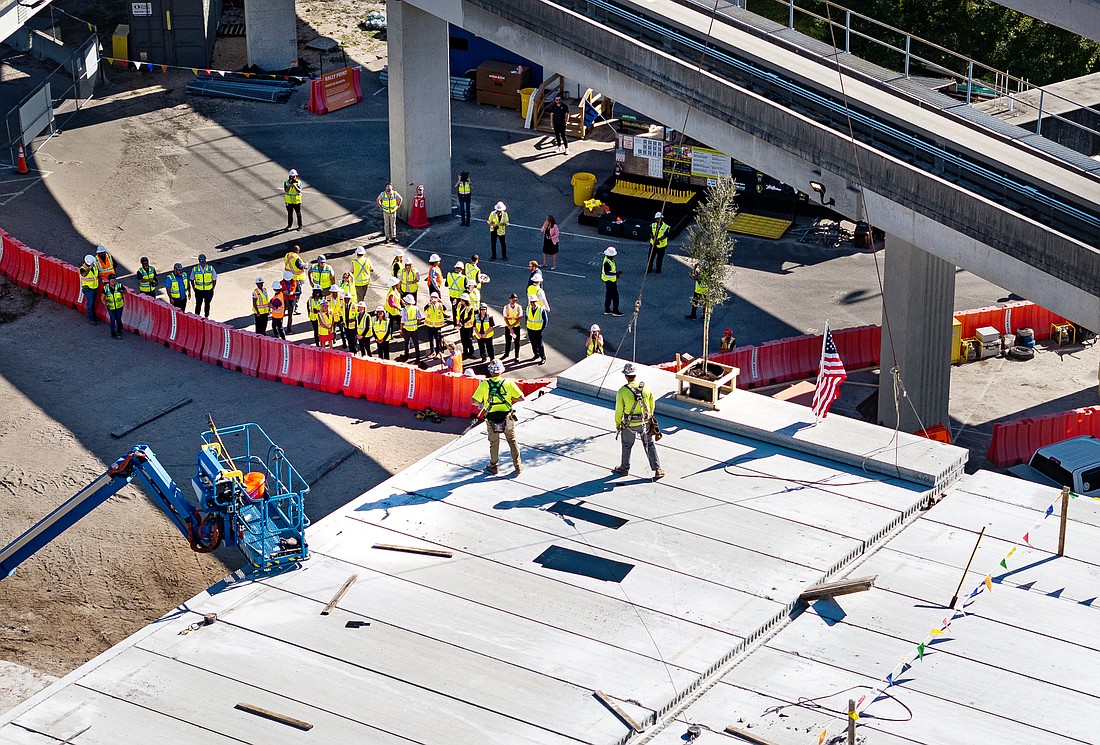 Workers take part in the Jacksonville Transportation Authority topping-out ceremony for the U2C Autonomous Innovation Center at 650 W. Bay St. in LaVilla. The event marked the installation of the final structural beam for the facility Oct. 24.