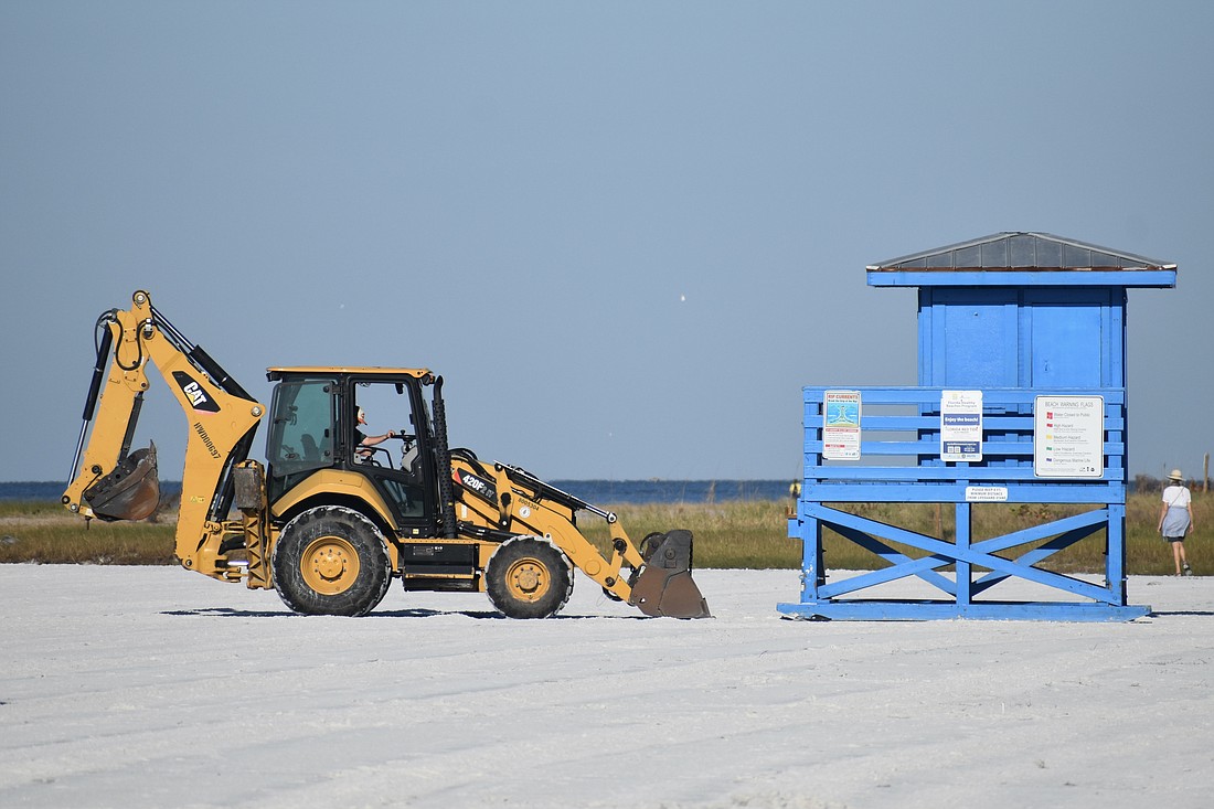 A backhoe sits on the beach as Sarasota County continues reopening preparations.