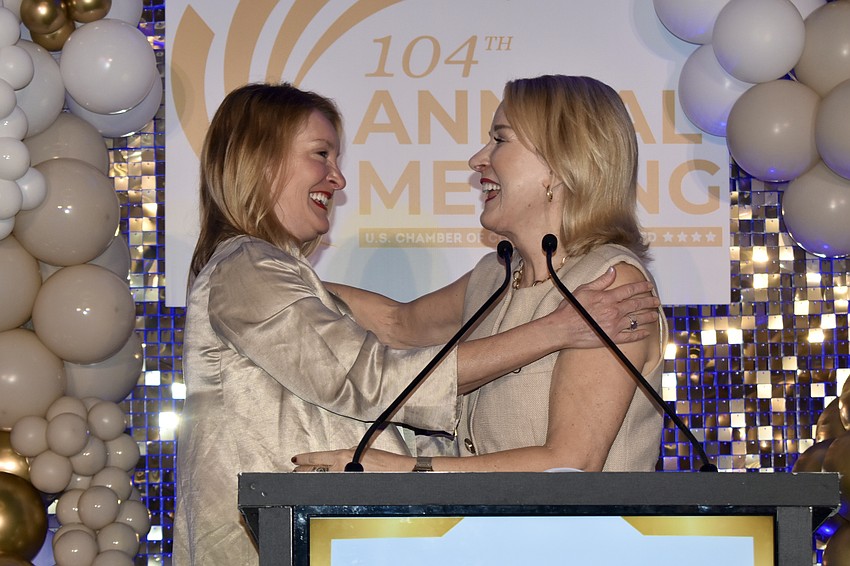 Observer Media Group President Emily Walsh greets Teri Hansen, immediate past chair of the chamber, as she is presented with the award.