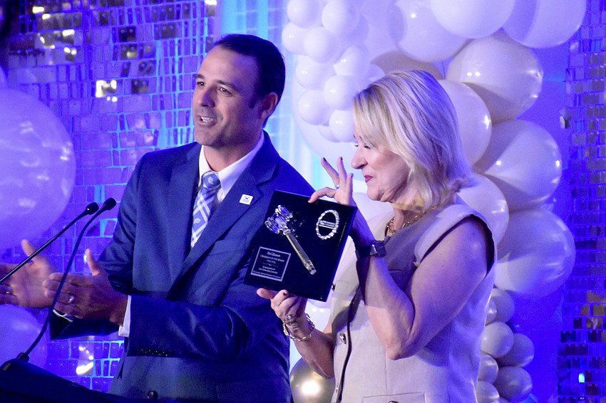 Sarasota Chamber Chair Joe Hembree offers immediate past chair Teri Hansen something to commemorate her time in the role.
