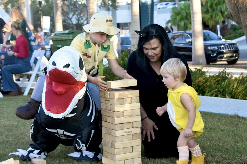 Silas Devereuz, 9, Angela De La Rosa and Wells Faulkner, 1, work together on a Jenga tower.