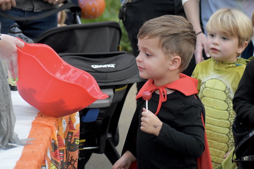 James Cowgill, 3 and Zeke Fernandes, 3, trick-or-treat at one of the stations by Gulf Coast Community Foundation.