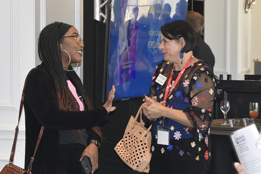 Dana Yawn, who provided the event's stage display through her company Party Popper Events, talks with Kenji Trujillo