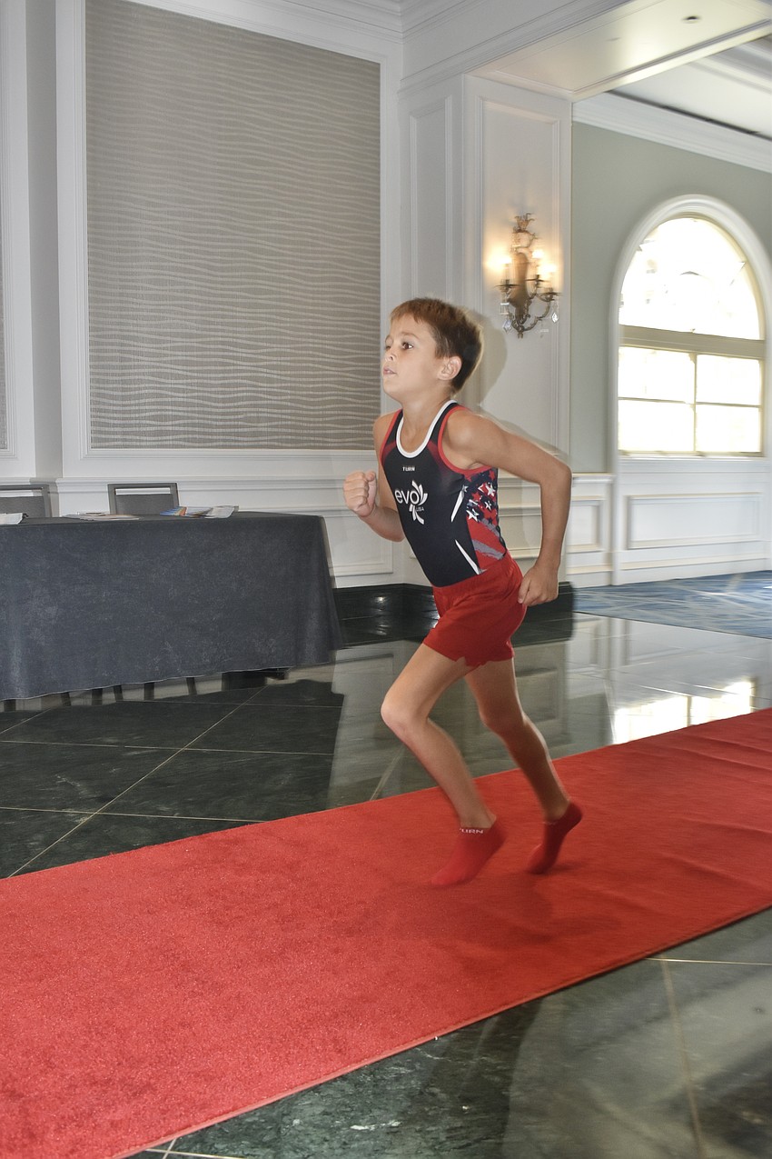 Blake Kilroy, 11 of EVO Gymnastics, makes a run down the red carpet of the hotel.