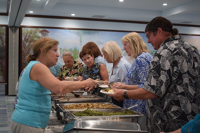 Charmaine Francis serving John Gornto at the St. Mary Star of the Sea potluck.