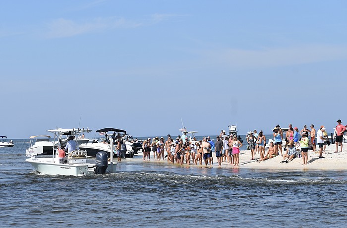 The public gathers at the entrance to Midnight Pass on Oct. 26, 2024, as boats make their way through the opening.