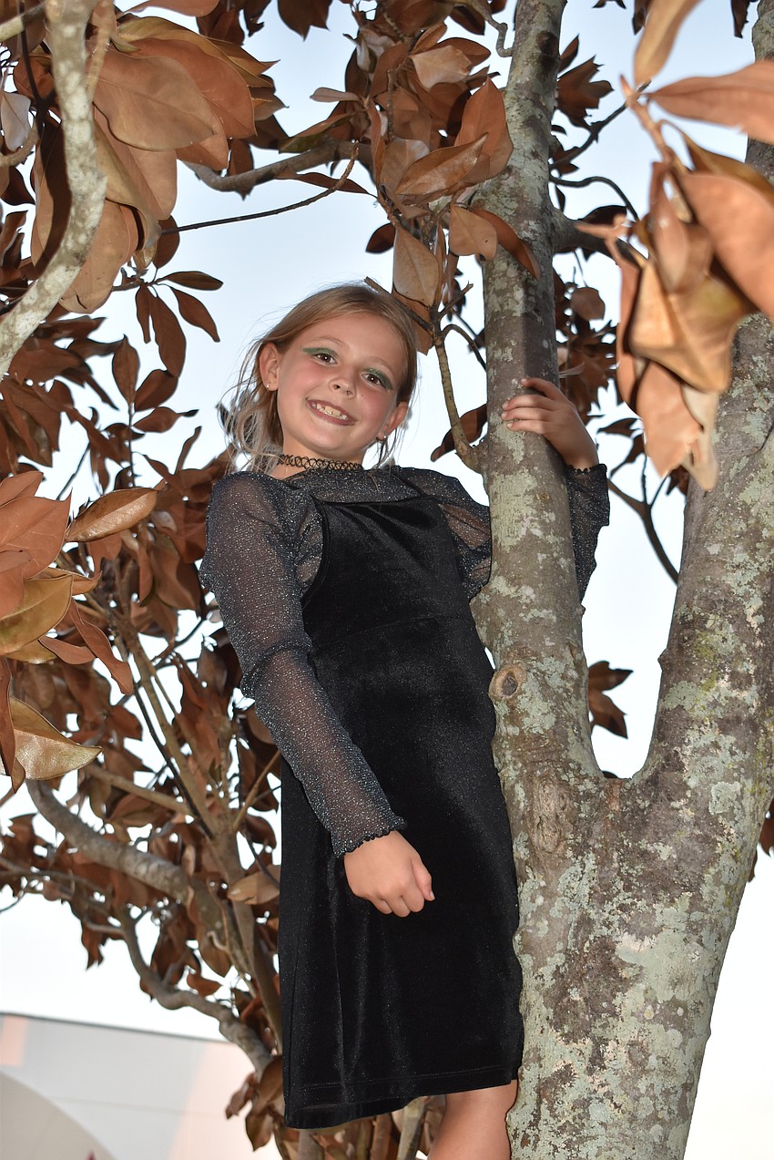 Lakewood Ranch's Olive Holmes, 7, climbs a tree while waiting for BooFest to start.