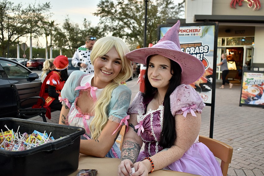 Bartender Kaylee Matherly and manager Erin Scott pass out candy for Pinchers.