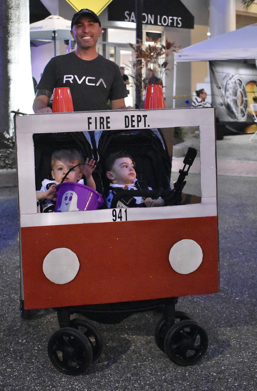 Ed Houghton pushes 22-month-old Lucas and Noah. The twins are dressed like Dalmatians.