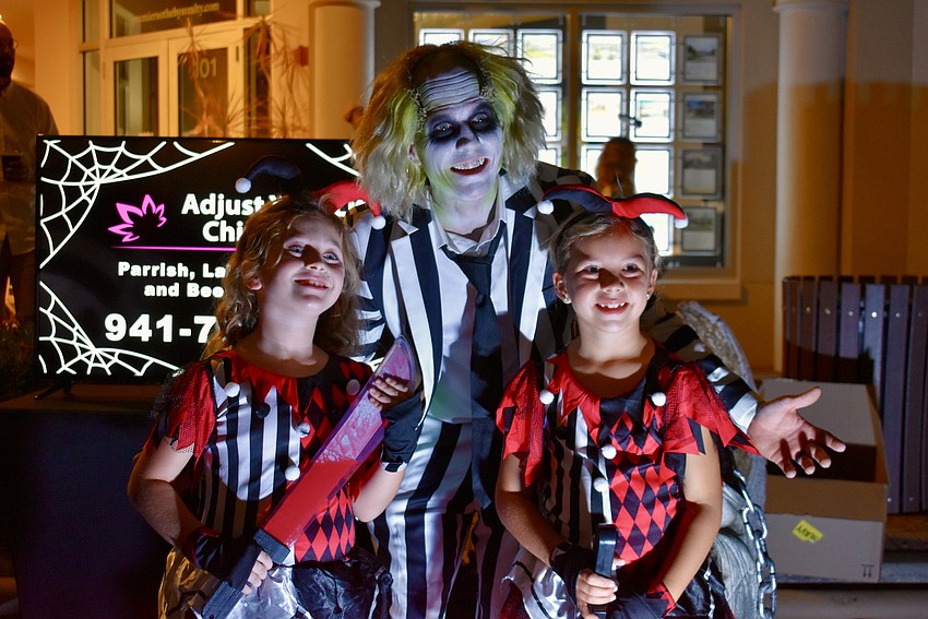 Ensley Romdenne and Brooklyn Stosick pose with Beetlejuice at the Adjust Your Life Chiropractic tent.