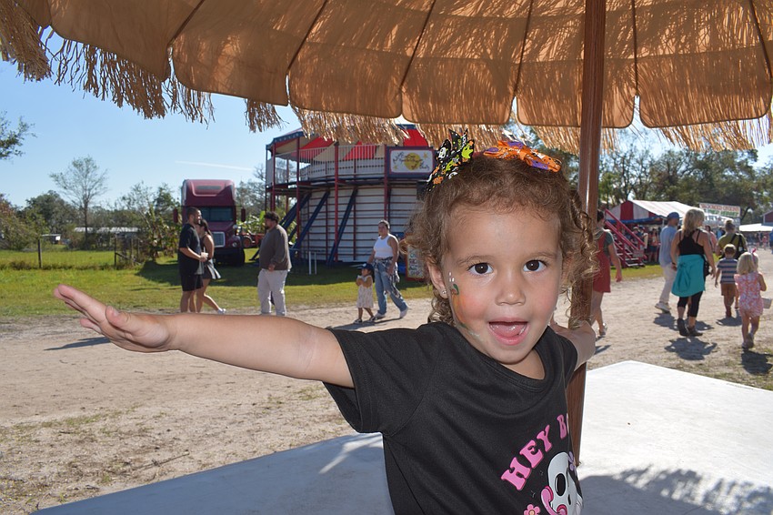 Sarasota 2-year-old Gia Colon shows off the painted pumpkin on her cheek.