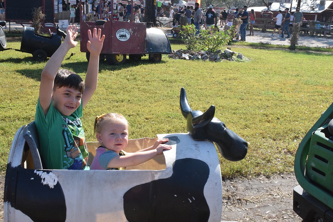 Myakka City's 7-year-old Ryder Tripp and 1-year-old Rowan Tripp take a ride in the cow train.