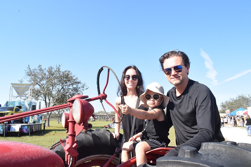 North Port's Inna Bauman, 2-year-old Jackson Bauman and Rus Bauman try out a tractor.