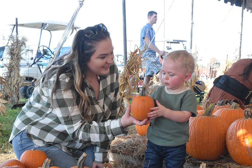 Hillsborough County's Makenzie Strange and 1-year-old Braxton Carroll check out the variety of pumpkins available.