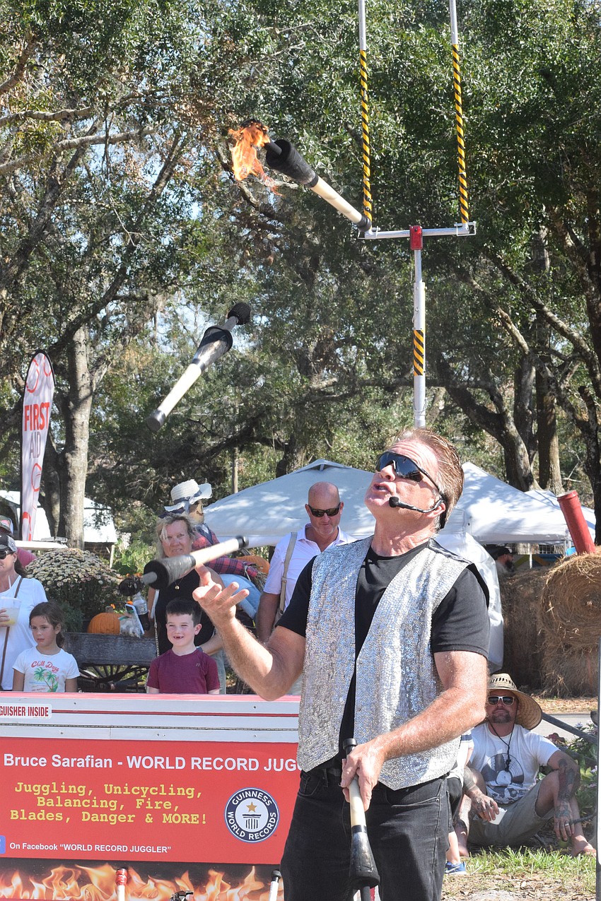 Bruce Sarafian juggles with fire, amazing the crowd.