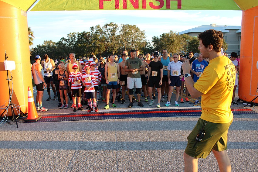 Race Director Carl Albano gives final directions before starting the Boo Run, which drew about 550 participants.
