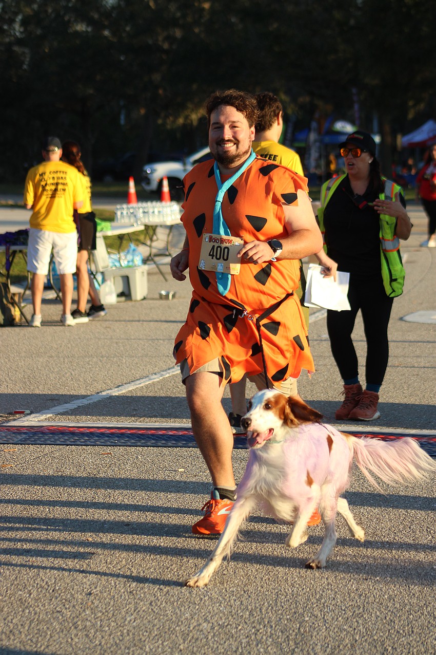 Bradenton's Joseph Farabee has a yabba dabba doo good time in the Boo Run with his dog Merl.