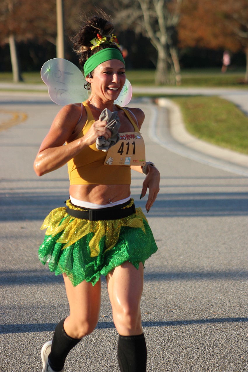 Amanda Patten of North Port and her fairy wings soar across the finish line at the Boo Run.