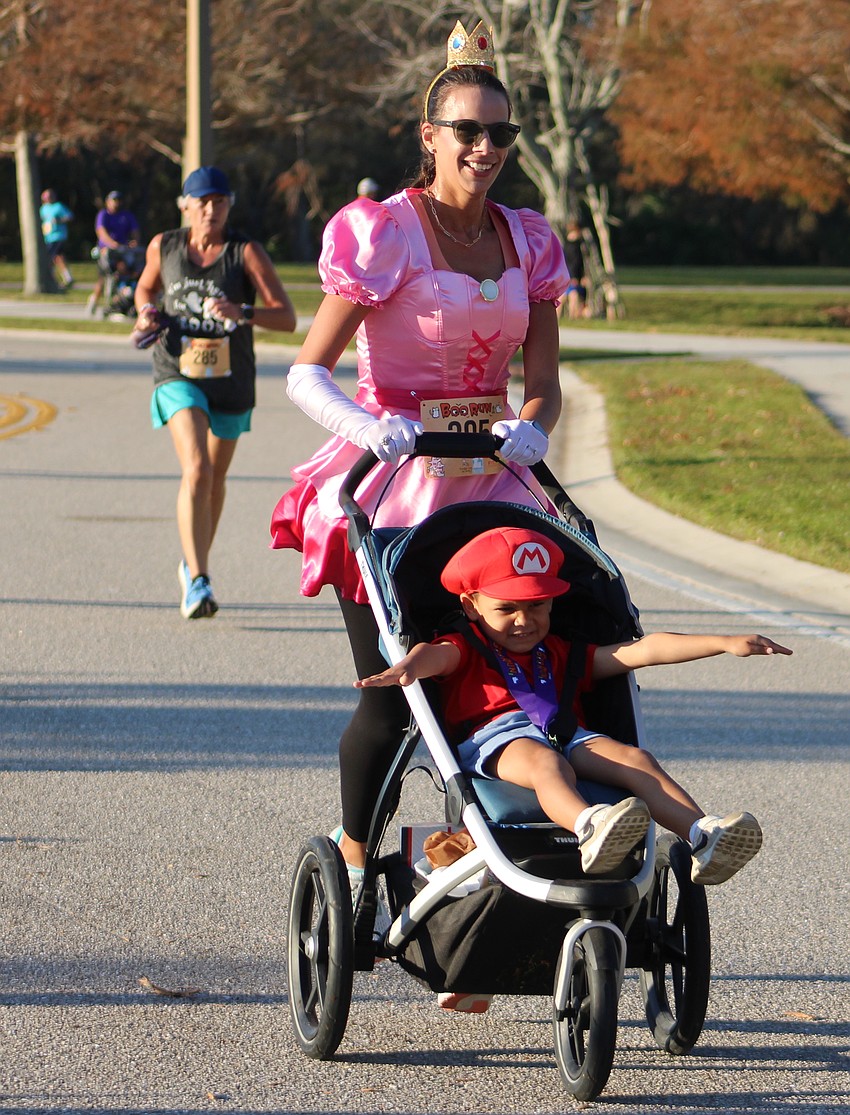 Lakewood Ranch's Cassie Gallego and 4-year-old Jacob Gallego are happy to reach the finish line of the Boo Run.