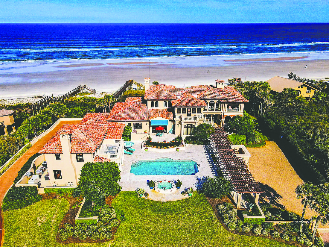 Oceanfront three-story home features six bedrooms, seven full and two half-bathrooms, guesthouse, elevator, theater, wine cellar, pool, two hot tubs, porches, patio, deck, balcony, four-car garage and dune walkover.