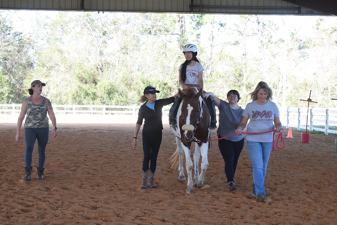 Amber Tarbet takes 13-year-old Leah Barros through her riding lesson with the help of Martha Murphy, Lisa Hughes and Sheryl Aguilar. SMART with Heart is looking for more volunteers and instructors to serve more people.