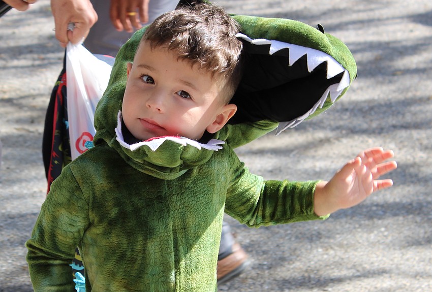 Kiddie Academy student Liam Stipakov knows alligators need candy, too, as he walks during the Halloween parade.