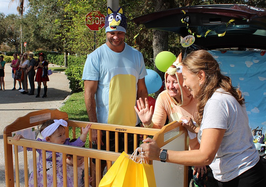 Ava Quinones enjoys the ride along with Keian McCleary in the crib while Michael DeSoe, Kaitlin DeSoe and Angela Cabrera show them a little love.